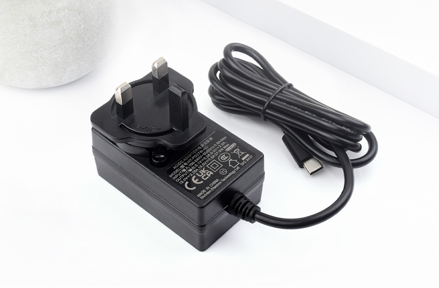 桌面上的树莓派5适用的英规27W USB Type-C电源插头，线长1.2米，绕线完整
