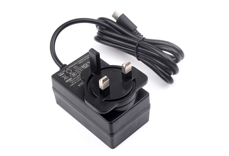 桌面上的树莓派5适用的英规27W USB Type-C电源插头，线长1.2米，绕线完整